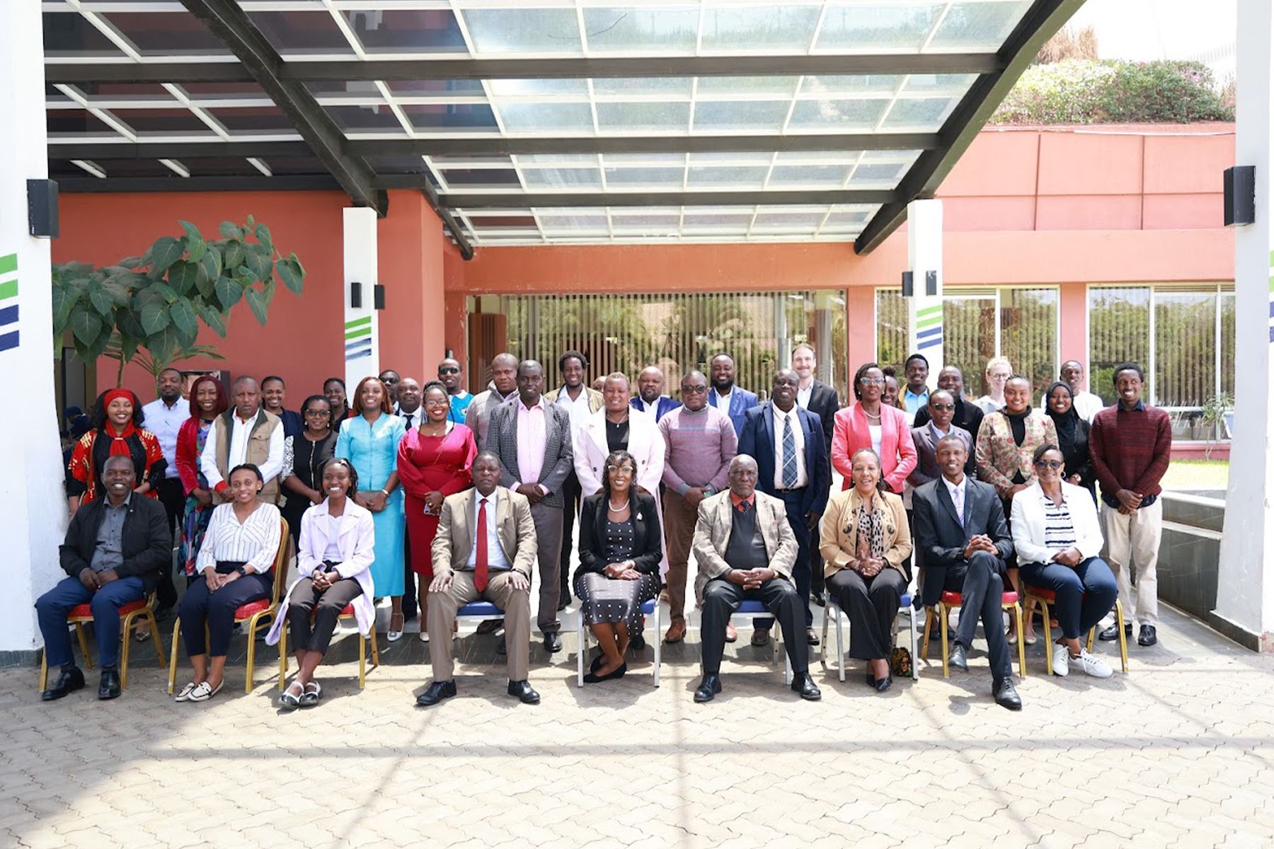 Commission officers and private-sector stakeholders in a group photograph outside a conference venue.