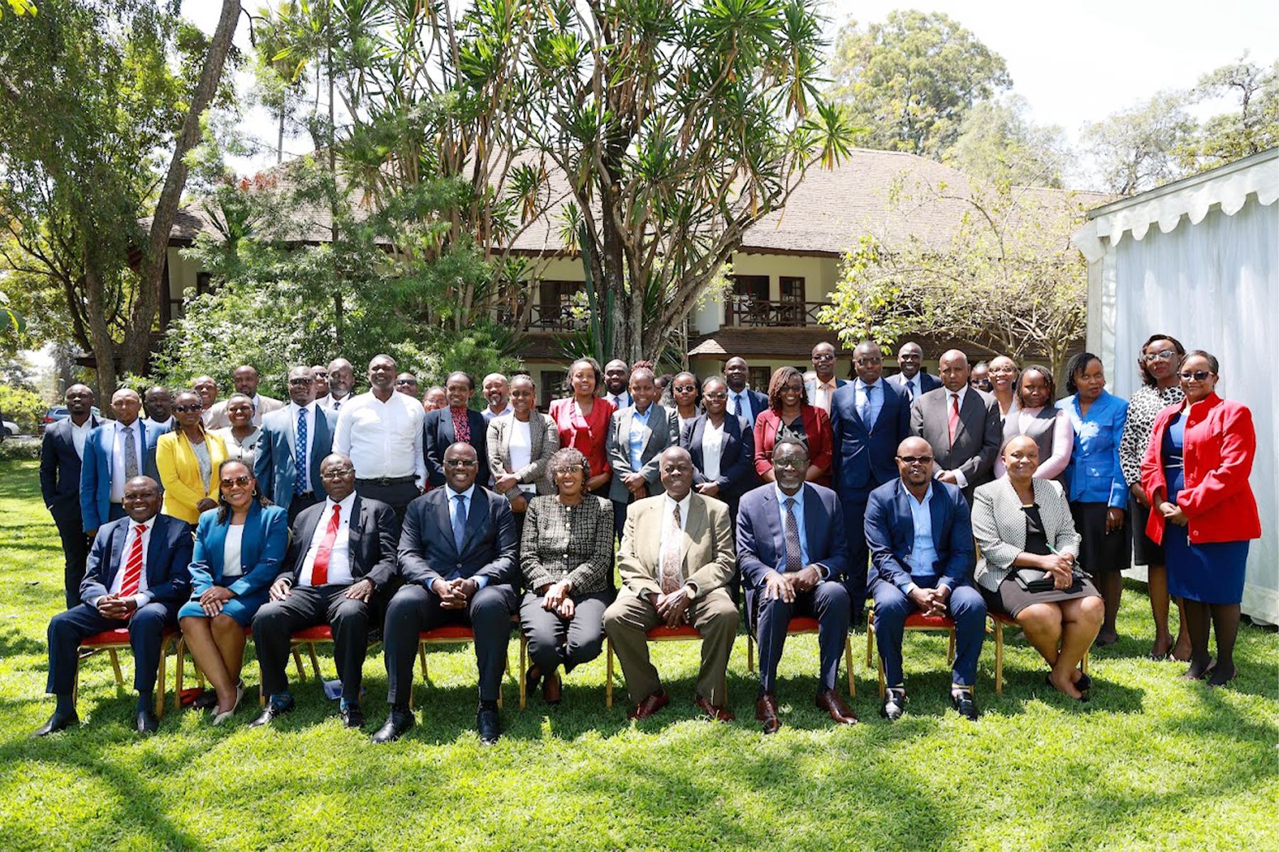 The Chairperson and the Commission Secretary seated in a garden with representatives of ministries, departments and agencies.